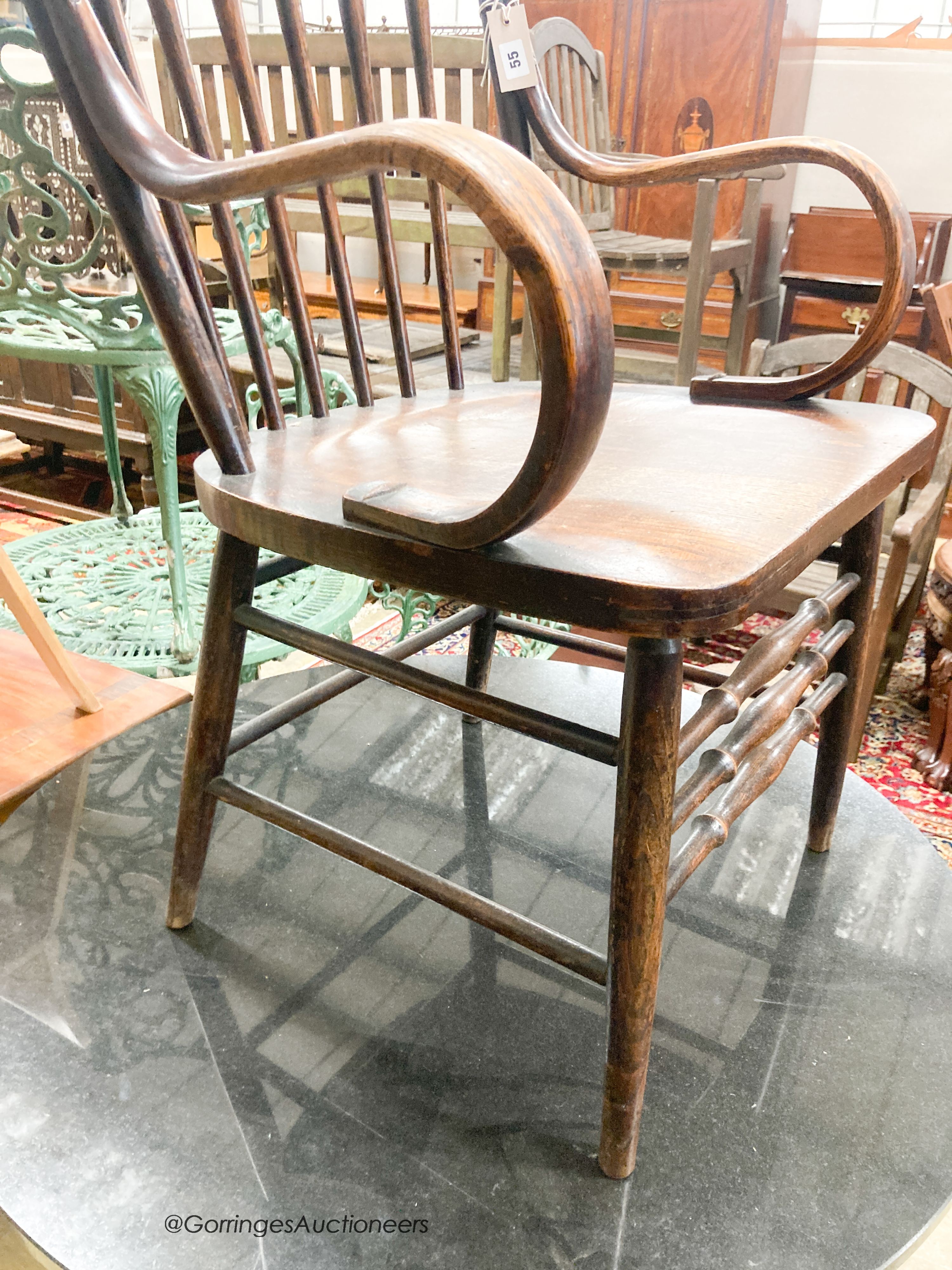 A late Victorian ash and elm comb back elbow chair